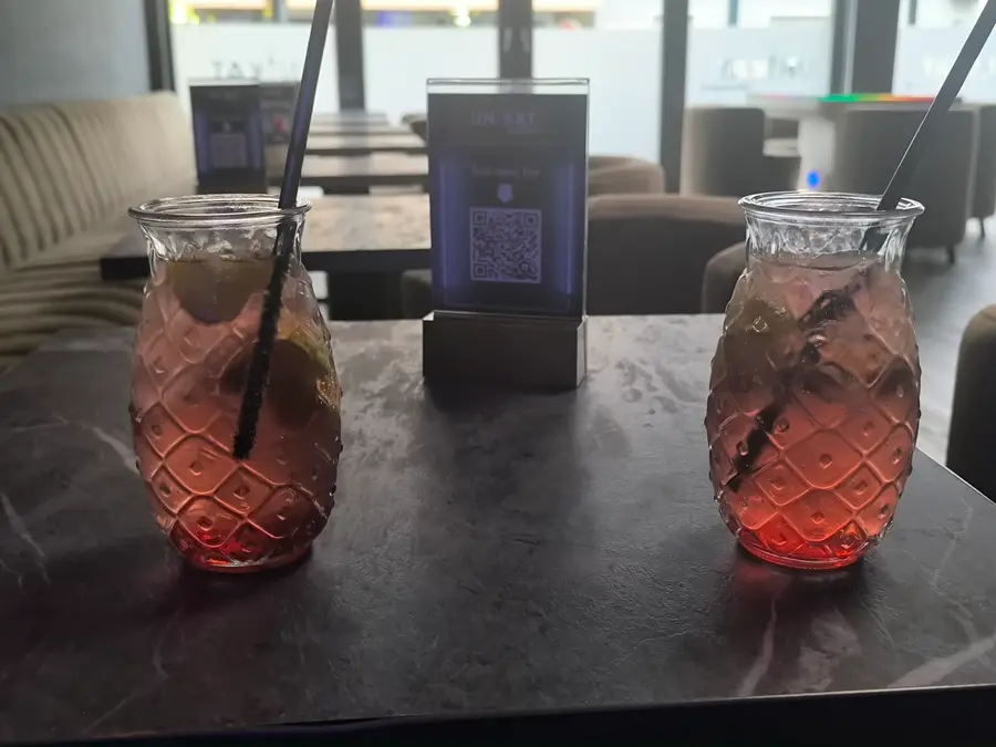 Zwei Cocktails in Gläsern mit Rautenmuster auf einem dunklen Marmortisch