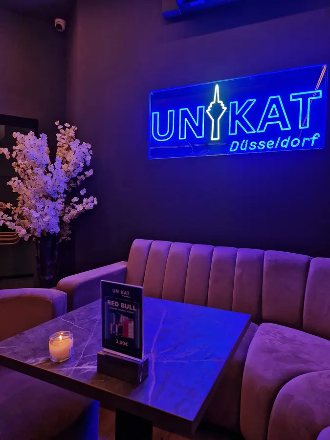 Neonschild Unikat Düsseldorf über dem Samtsofa